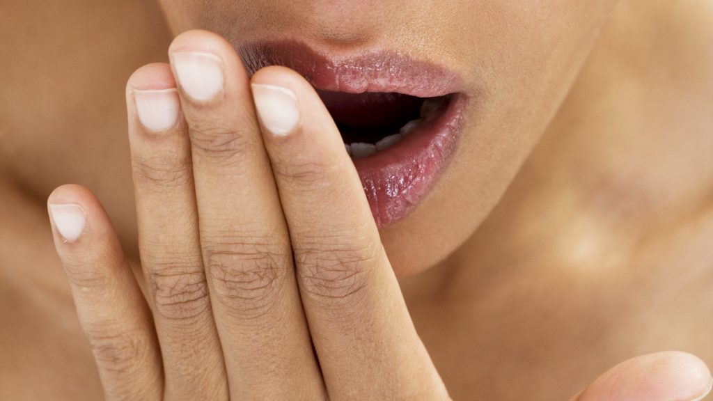 woman testing for bad breath
